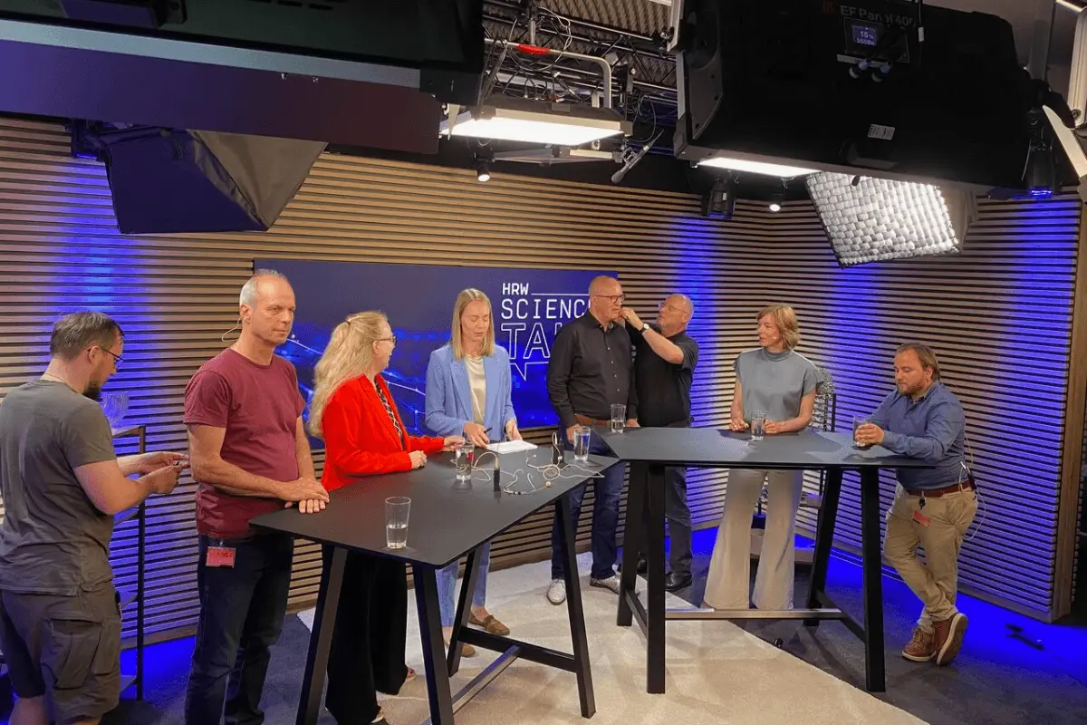 Techniker verkabelt Stefan Koshold vor dem Science Talk in den Fernsehstudios der FUNKE Mediengruppe.